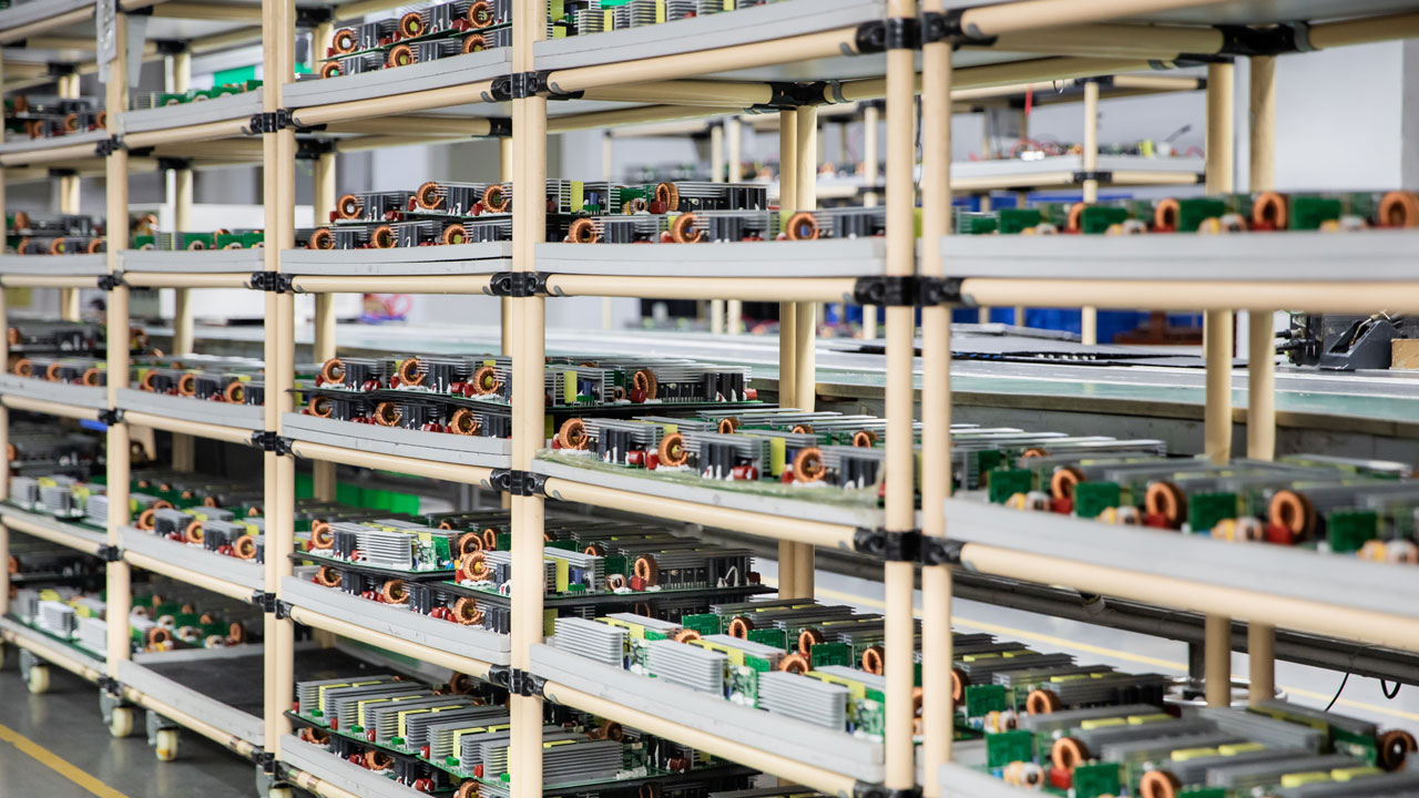 Rows of commercial PCBs organized on shelves for high-volume manufacturing and quality control in electronics production