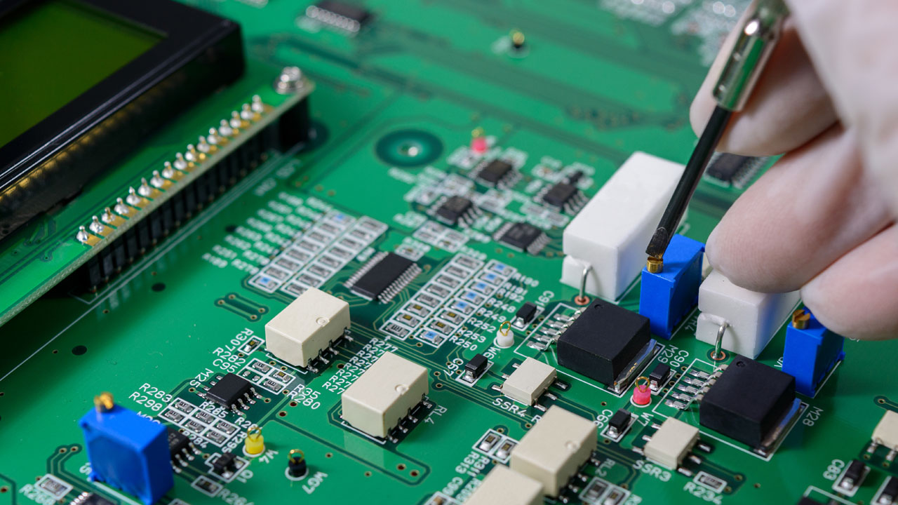 Technician inspecting high-reliability industrial PCB with mounted components for factory automation systems