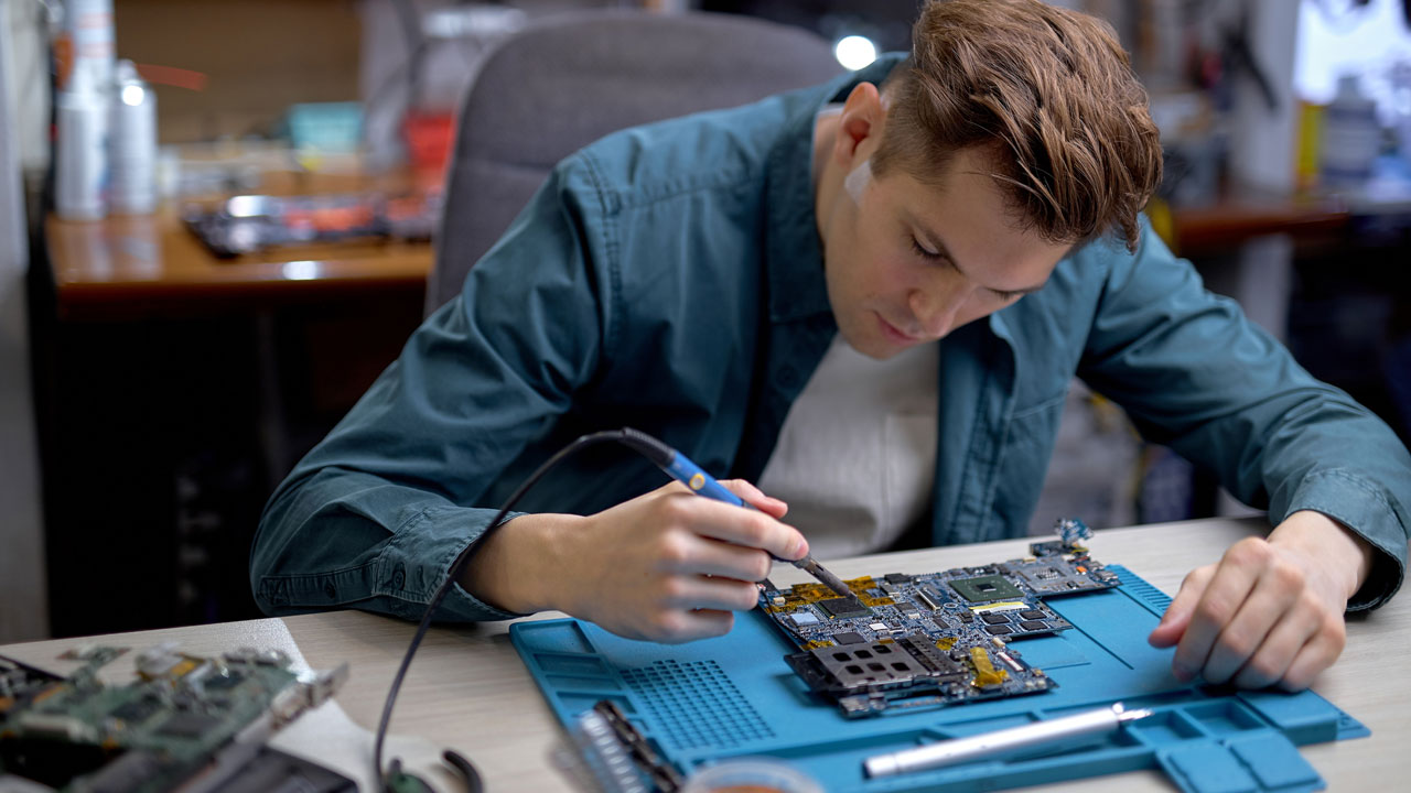 Technician testing PCB for reliability and quality control in medical electronics assembly